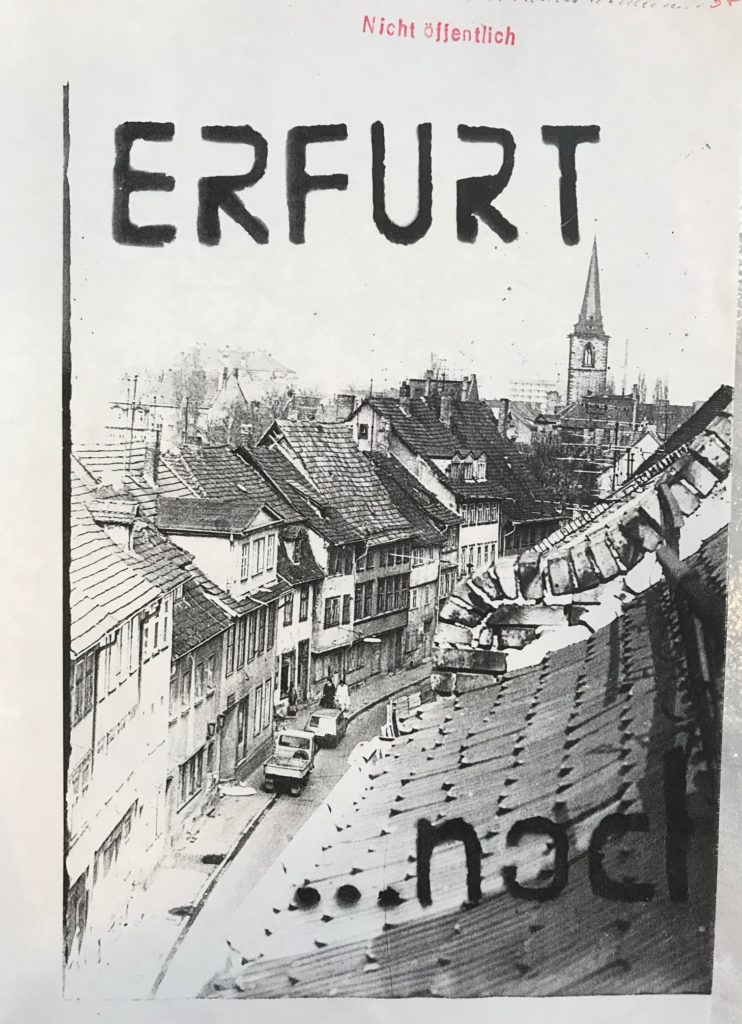 Ein verfallener Straßenzug und mit Schablonenschrift die Aufschrift "Erfurt... noch"